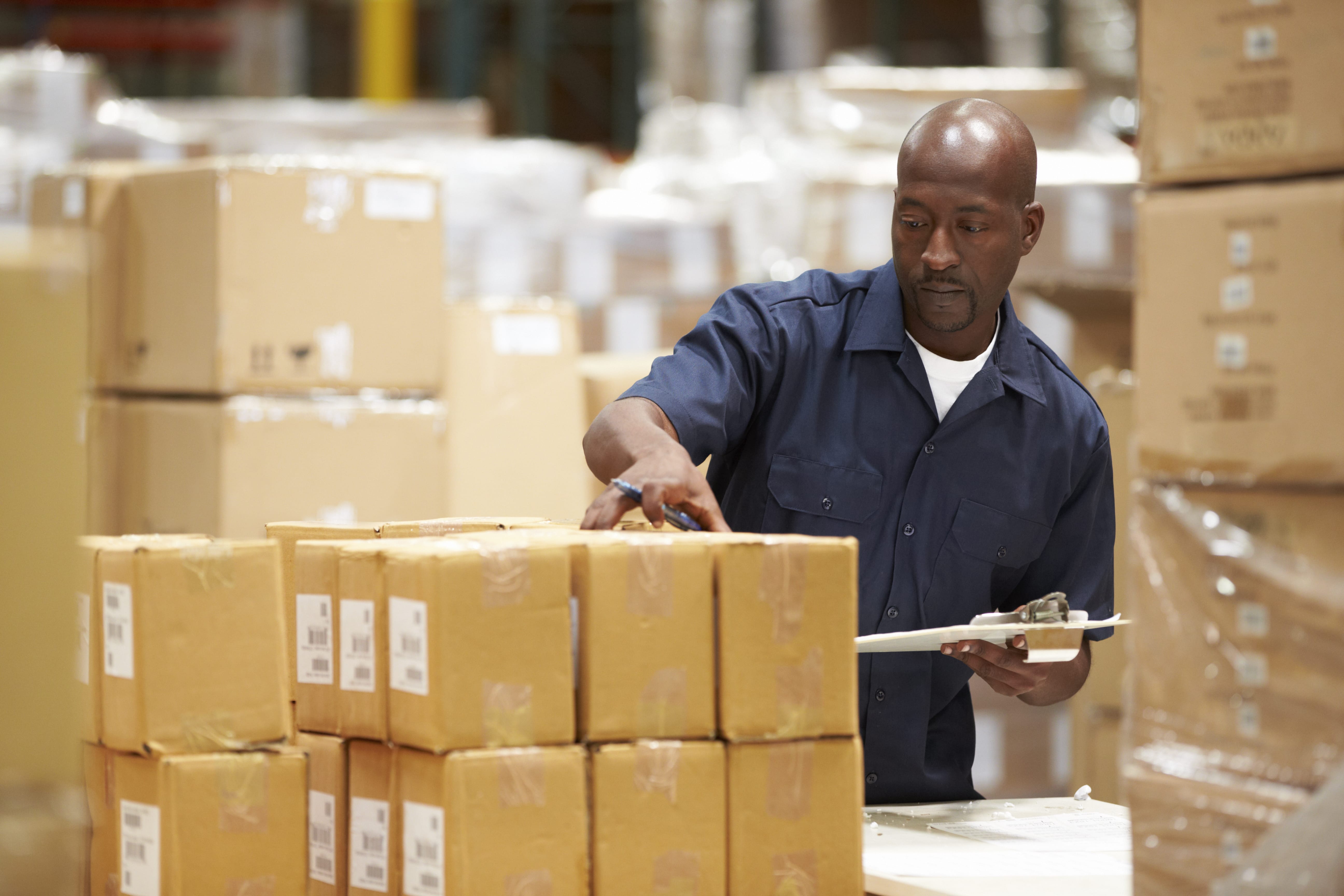 Delivery working inspecting parcels in a warehouse