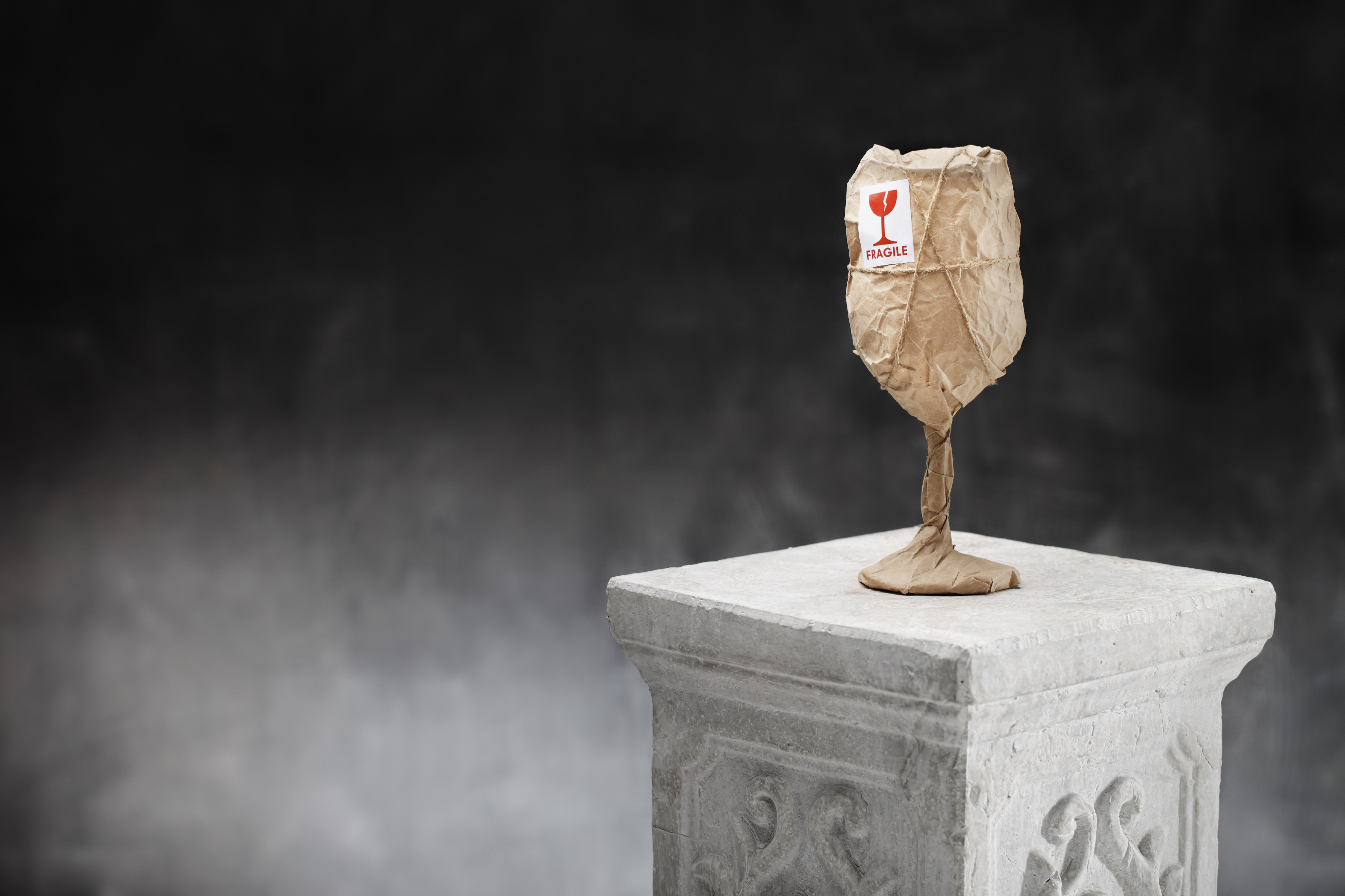 An obviously fragile wine glass wrapped in paper with a sticker marked FRAGILE