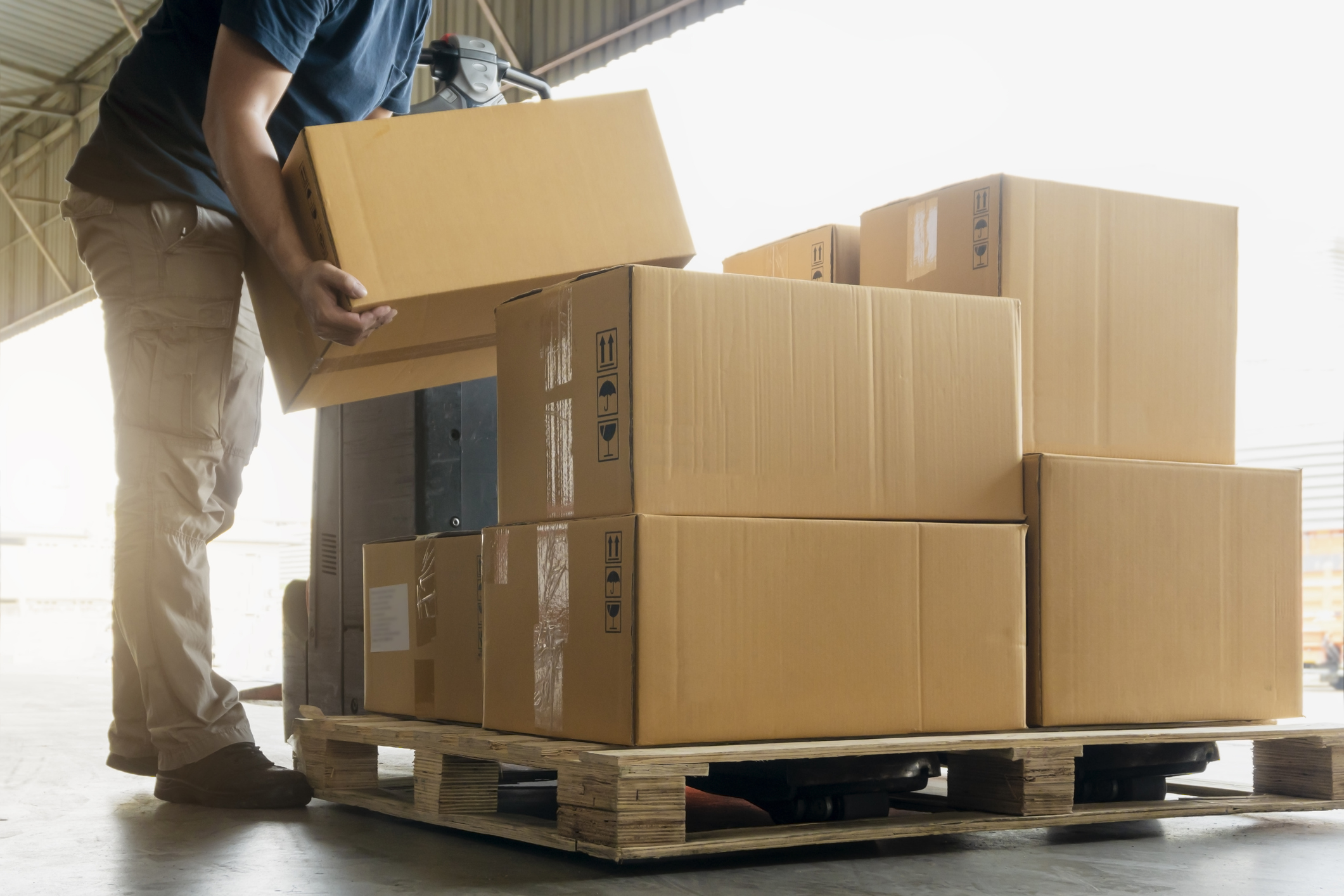 person stacking boxes on to a pallet