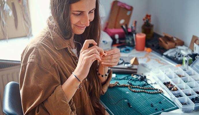 Woman making jewellery from home to sell online