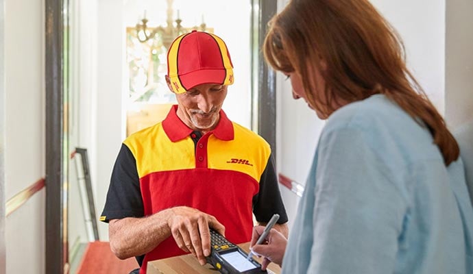 DHL eCommerce UK driver delivers parcel sent using recorded delivery, recipient signs handheld device