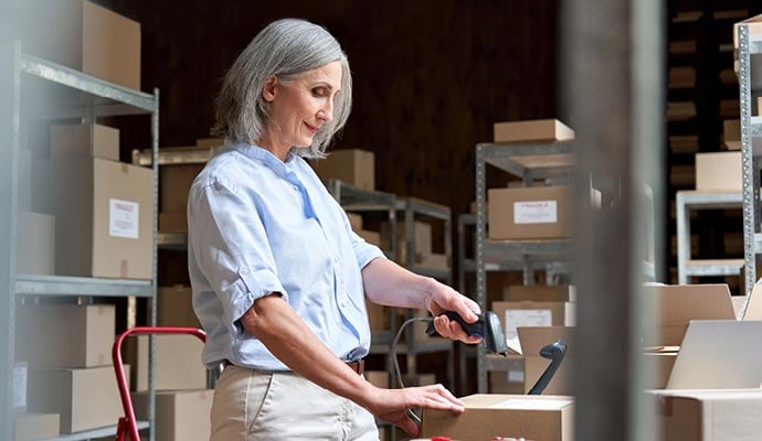 Woman in warehouse prepares customers orders ready for collection