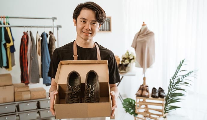 Online retailer packaging shoes which he has sold online